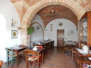 een restaurant met tafels en stoelen en een bakstenen muur bij Agriturismo Il Casolare Di Bucciano in San Gimignano