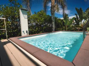 a swimming pool in a backyard with palm trees at CasaSol Deluxe villa sulla Spiaggia con Piscina e Jacuzzi By Sicily Home Solutions in Alcamo