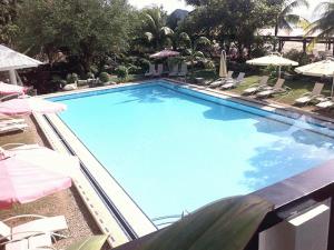 a large blue swimming pool with chairs and umbrellas at Jamont Hotel in Sipalay +101 photos