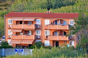 an orange apartment building on the side of a hill at Apartments Jela in Metajna