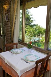 une table avec un chiffon de table blanc et une fenêtre dans l'établissement Hotel Da Angelo, à Assise