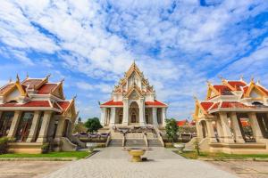 a building with a fountain in front of two buildings at Baan Chomphu in Prachuap Khiri Khan