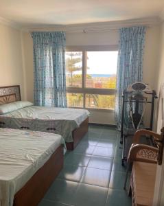 a bedroom with two beds and a window at Alshrooq Village 97 in Borg El Arab