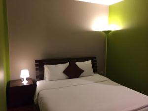 a bedroom with a bed with two lamps on it at Baan Chomphu in Prachuap Khiri Khan