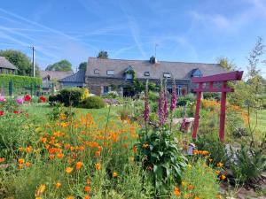 a garden with a red bench in a field of flowers at La Lézardière in Pleugriffet