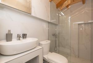 a bathroom with a sink and a toilet and a shower at Grande Blu by NG Villas in Afitos