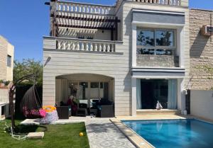 a house with a swimming pool in the yard at Alshrooq Village 97 in Borg El Arab