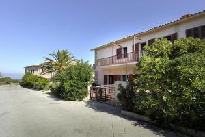 a building with a palm tree in front of it at Le Villette di Capo Testa in Santa Teresa Gallura