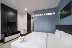 a bedroom with a bed with two pairs of slippers at Belleville hotel in Phetchabun