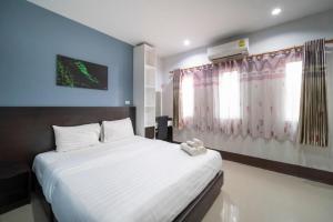 a bedroom with a large white bed in a room at Belleville hotel in Phetchabun