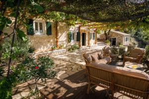 a patio with two benches and a house at Castelli Cottage in Acharavi