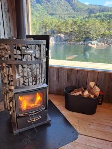 a stove with a fire in a room with a window at The Old Cabin in Vikedal