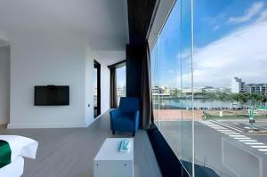 a room with a blue chair and a large window at Read River in Anping
