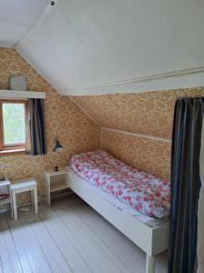 a small bedroom with a bed and a window at The Old Cabin in Vikedal