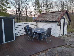 a patio with a table and chairs on a deck at The Old Cabin in Vikedal