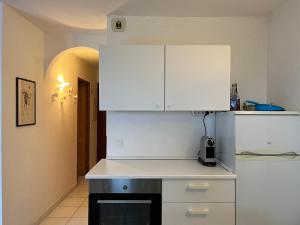 a kitchen with white cabinets and a black stove at Oro 60 in Conca
