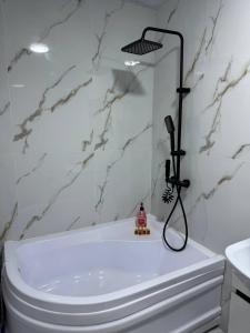 a bathroom with a white tub and a shower at Runa modern flat in Samarkand +14 photos