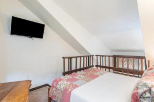 a bedroom with a bed and a flat screen tv at Manitou Lodge 8 by Alpine Lodging Telluride in Telluride