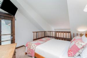 a bedroom with two beds and a flat screen tv at Manitou Lodge 11 by Alpine Lodging Telluride in Telluride