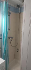 a shower in a bathroom with a blue shower curtain at Appartement vu mer in Le Barcarès