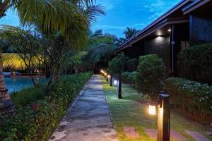 a walkway next to a house with lights on it at S Garden View Resort in Ban Bang Yai Chuai