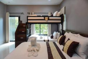 a bedroom with two bunk beds and a window at S Garden View Resort in Ban Bang Yai Chuai