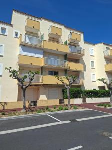 an apartment building with trees in front of it at Appartement vu mer in Le Barcarès