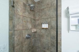 a shower stall with a glass door and a shower at Manitou Lodge 2 by Alpine Lodging Telluride in Telluride