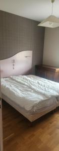 a bed in a room with white sheets on it at La Genetouze in La Genétouze