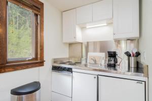 a kitchen with white cabinets and a stove top oven at Manitou Lodge 7 by Alpine Lodging Telluride in Telluride