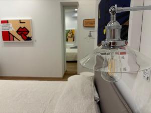 a glass lamp hanging on a wall in a room at Corsica Rooms in Termoli +2 photos