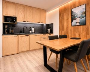 a kitchen with a wooden table and chairs at Apartmány Panorama Harrachov in Harrachov