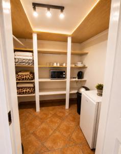 a kitchen with white shelves and a microwave at Zhantique Guest House 1- Unit 5 in Boksburg +3 photos
