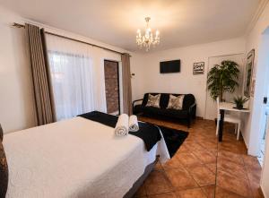 a bedroom with a white bed and a couch at Zhantique Guest House 1- Unit 5 in Boksburg