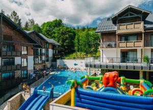 ein Pool in einem Ferienresort, in dem Menschen spielen in der Unterkunft Elements Hotel&Spa in Świeradów-Zdrój
