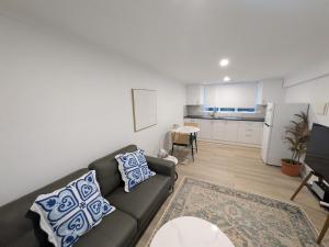 a living room with a couch and a kitchen at Private Coastal Sanctuary Beachside Escape in Bunbury