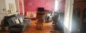 a living room with a couch and chairs and a tv at La Genetouze in La Genétouze
