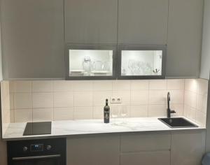 a kitchen counter with a sink and a bottle of wine at BlueBird Apartments in Latschach
