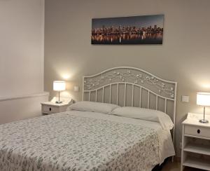 a bedroom with a bed and two night stands with lamps at Piso Covian in Ribadesella