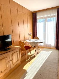 a living room with a table and a television at Ferienwohnungen Billovits in Kössen +5 photos