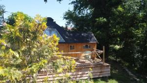 a small wooden house with a black roof at Auvergne Kota in Brugheas
