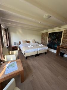 a bedroom with a large bed and a living room at Hotel Ter Linde in Zuidwolde