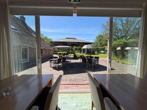 a view of a patio with tables and an umbrella at Hotel Ter Linde in Zuidwolde