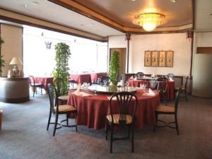 a restaurant with tables and chairs with red table cloth at Rihga Royal Hotel Niihama in Niihama