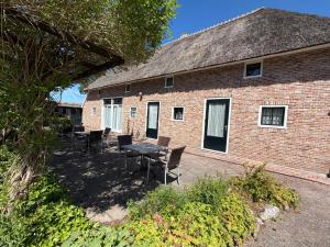 a patio with chairs and a table and a brick building at Hotel Ter Linde in Zuidwolde