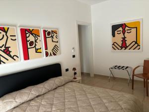 a bedroom with paintings on the wall and a bed at Corsica Rooms in Termoli