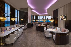 a restaurant with tables and chairs and a purple ceiling at Ascott Macau in Macau