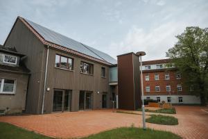 a large building with a brick courtyard in front at Pension Altes Schulhaus in Leuna