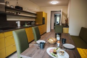 a kitchen with a wooden table with a plate of food on it at Pension Altes Schulhaus in Leuna