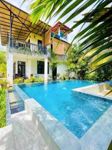 a swimming pool in front of a house at Meadow View Villa in Dickwella
